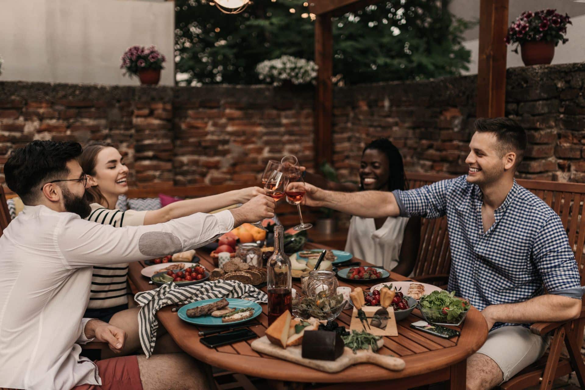 Group of friends enjoying an outdoor meal and making a toast.