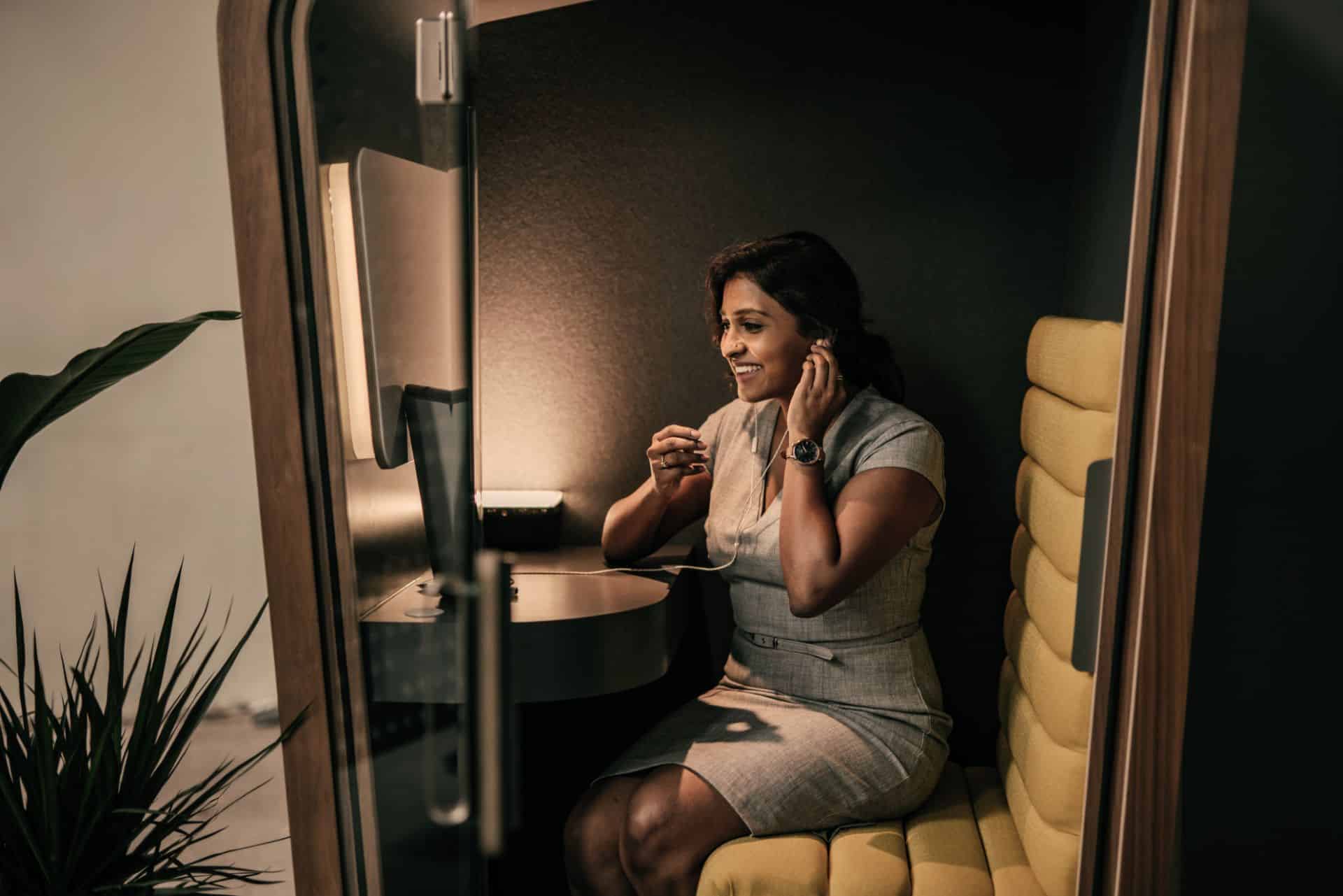 Person sitting at a desk and smiling while looking at a computer screen.