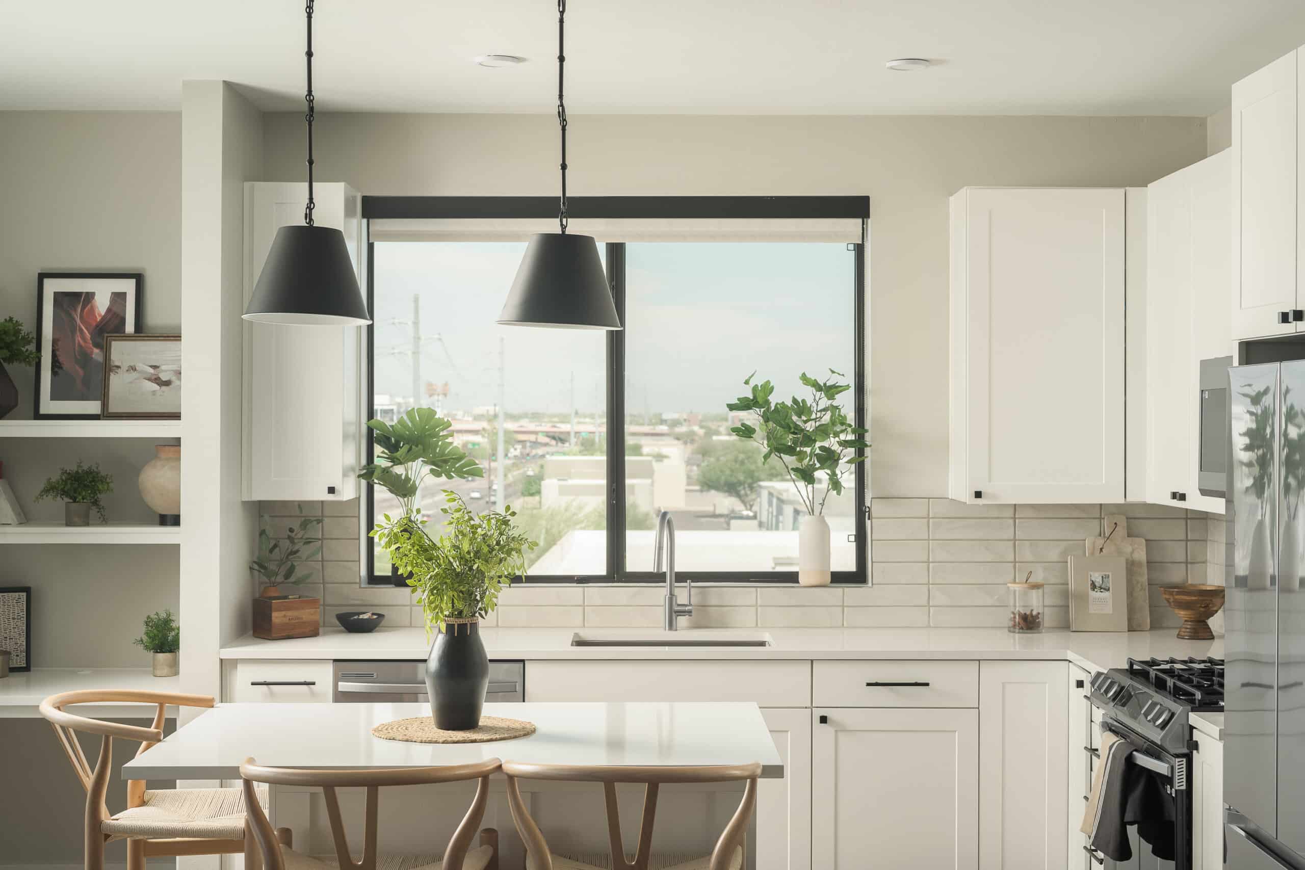 Spacious kitchen interior with natural lighting, featuring a dining area and pendant lights.