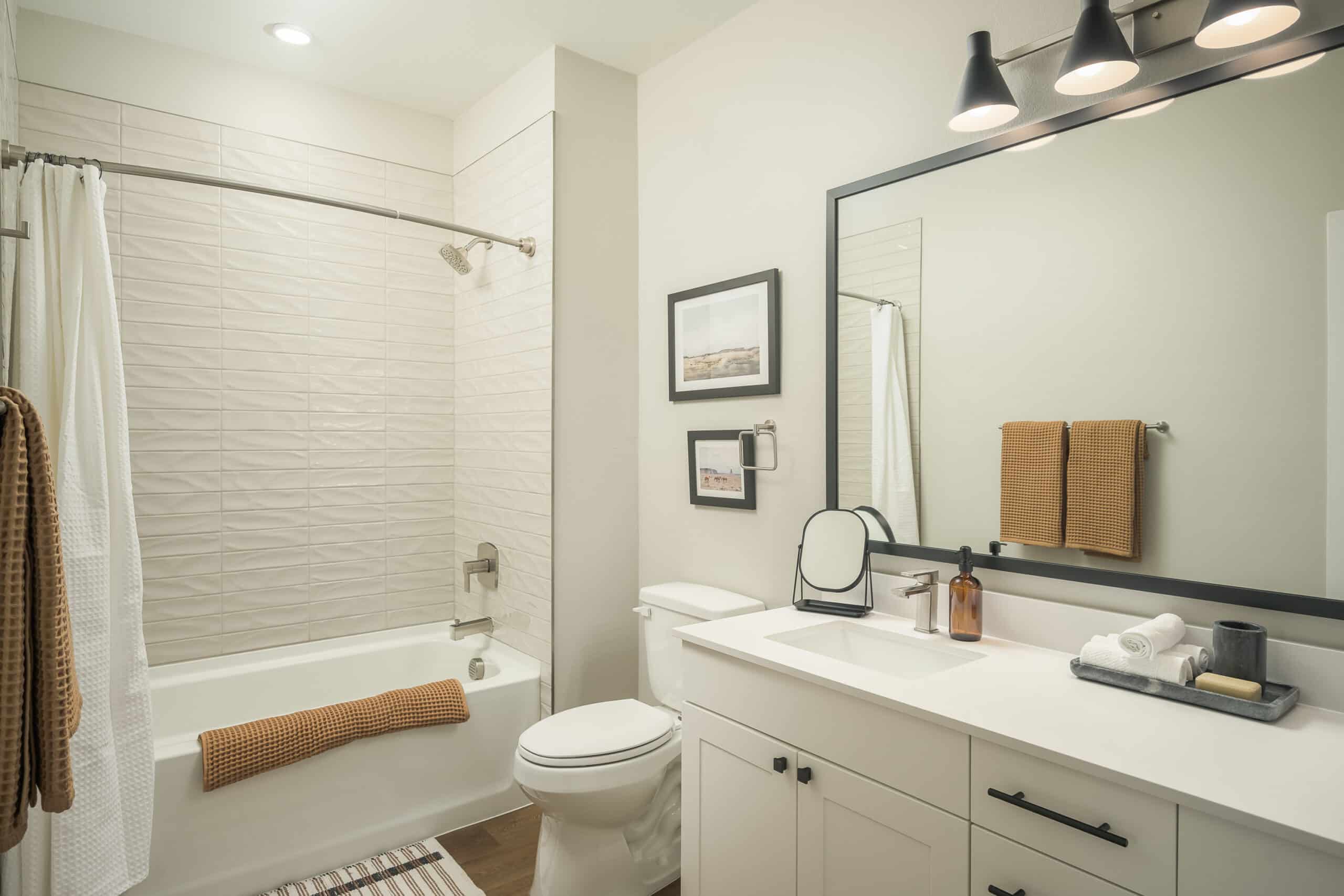 Modern bathroom interior with a bathtub, sink, mirror, and neutral color scheme.