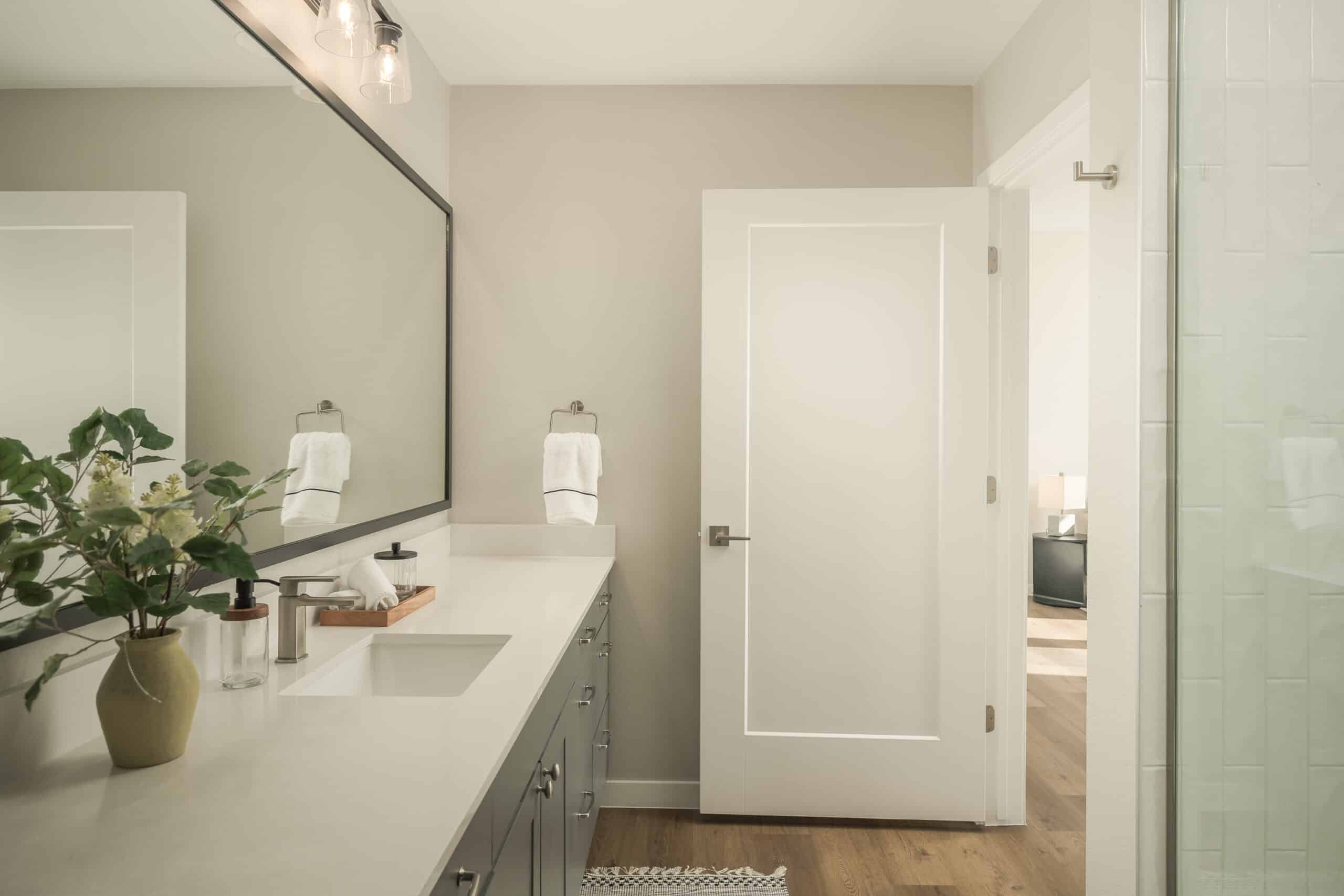Smith & Rio bathroom interior with double vanity and glass shower door.