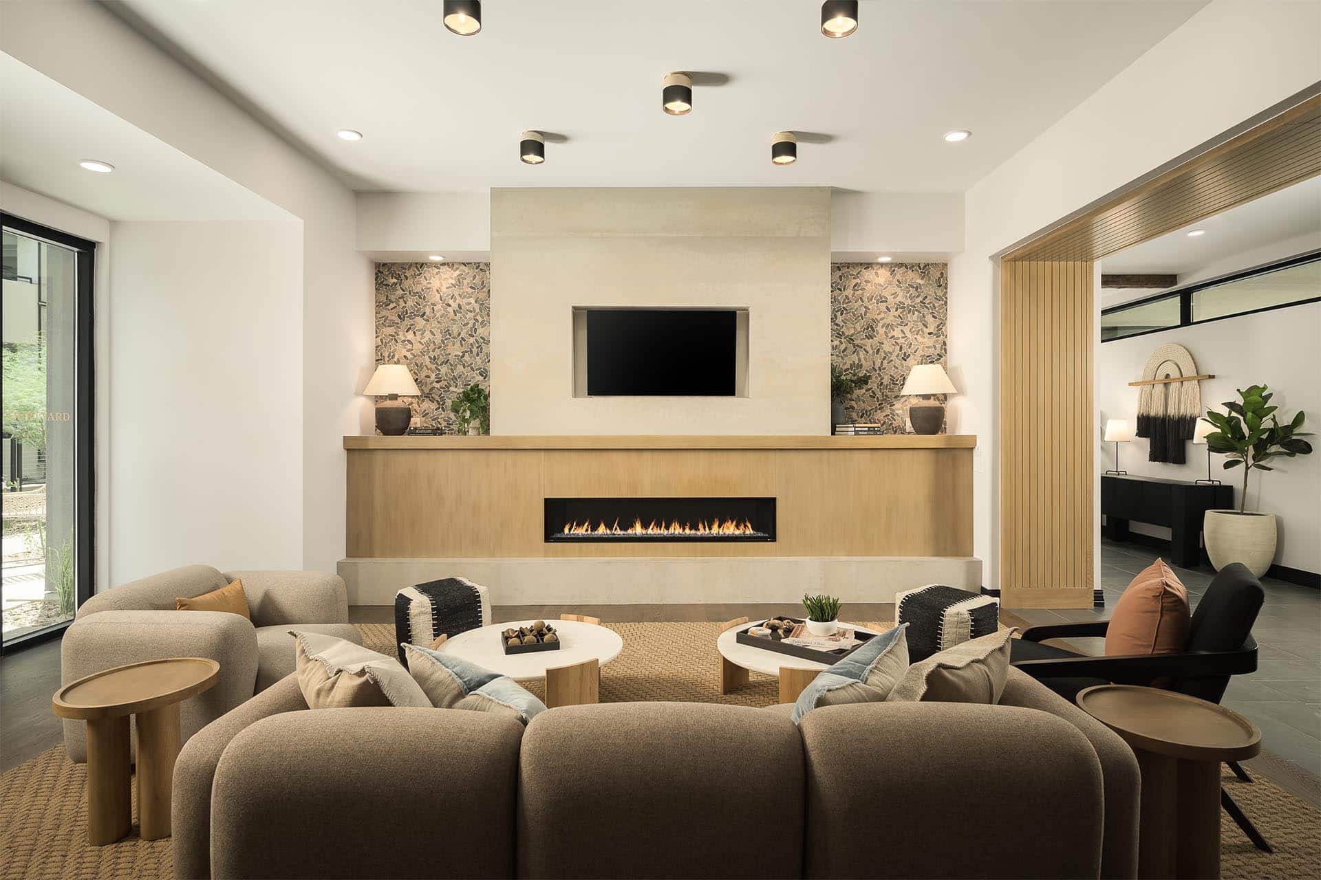 Resident lounge area with a fireplace, sectional sofa, and mounted television.