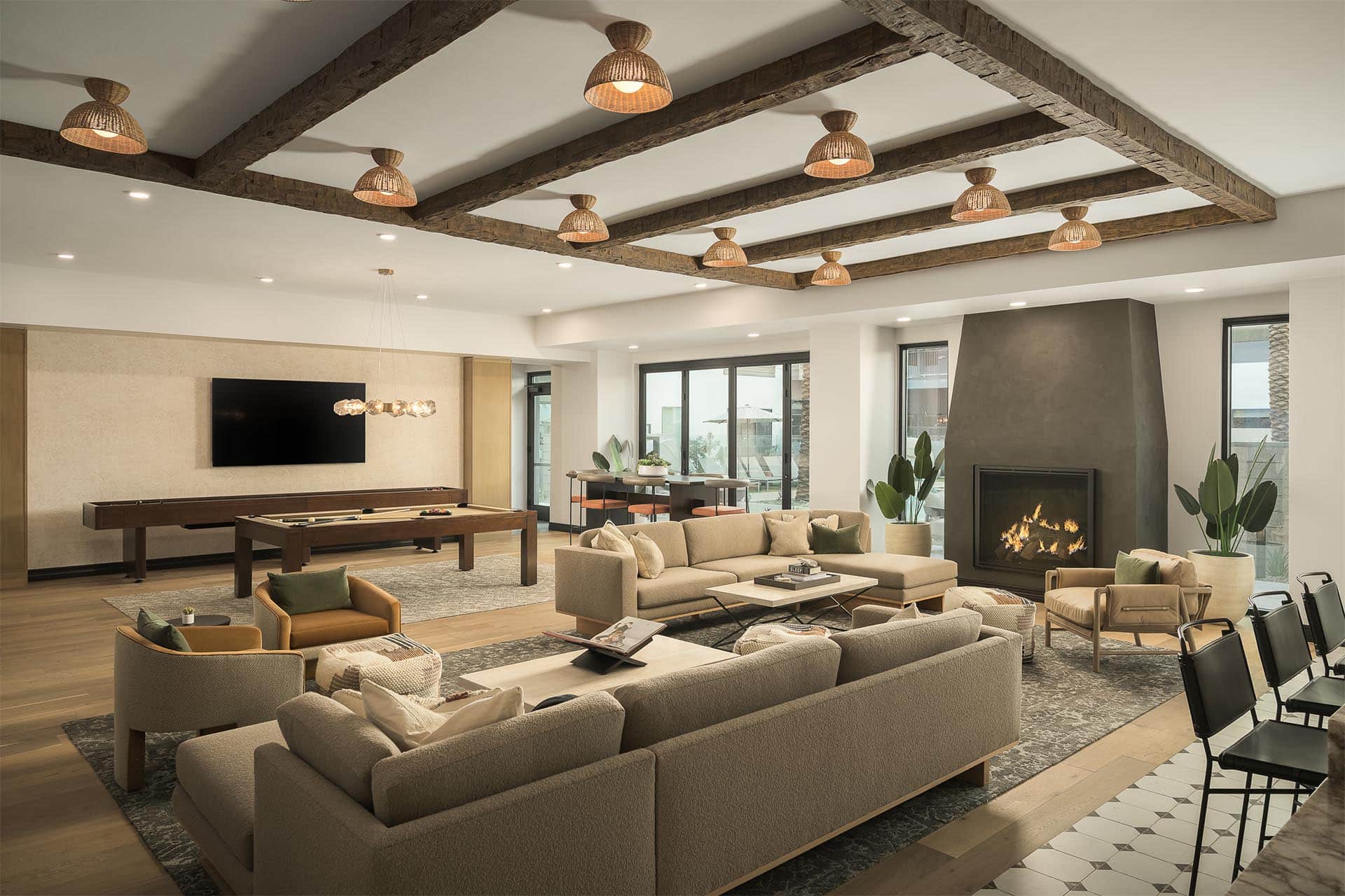 Smith & Rio lounge with a fireplace, exposed beam ceiling, and chic furnishings.